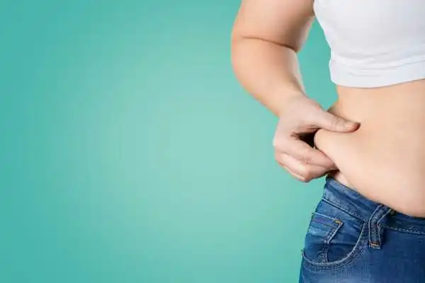 Image of woman pinching her love handles to show weight gain Newark on Trent
